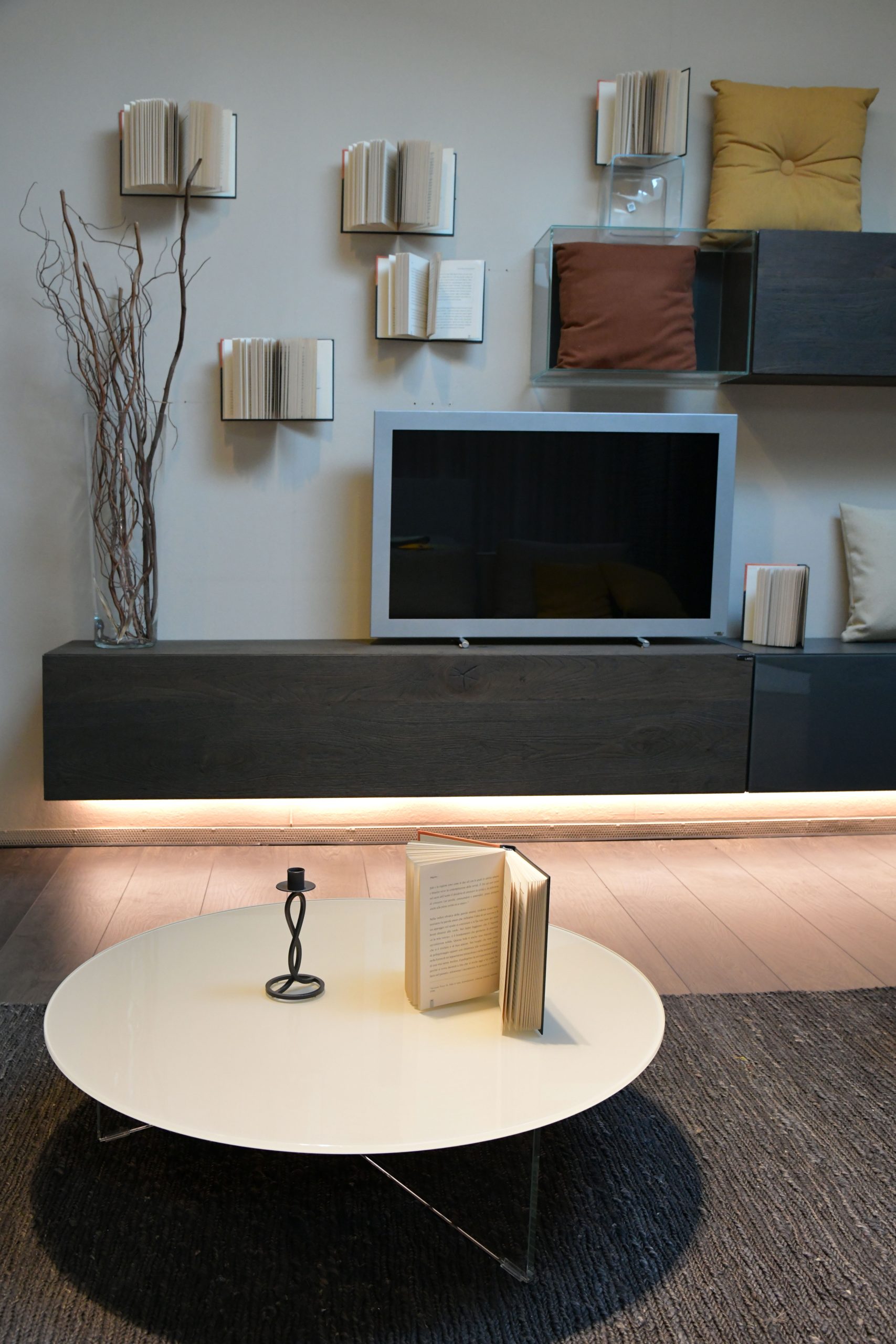 Contemporary living room in Rizza, Italy featuring artistic wall books and elegant furniture.